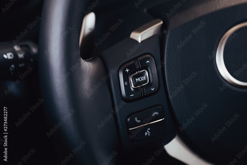 Audio control buttons on the steering wheel of a modern car