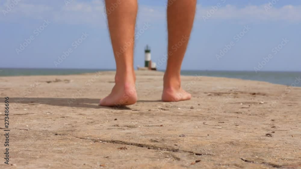 male legs on the pier by the sea, tourist on vacation male legs on the pier by the sea, tourist on vacation