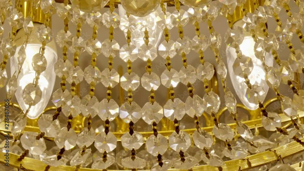 Close-up tilt-up shot of a crystal and gold chandelier Close-up tilt-up shot of a crystal and gold chandelier