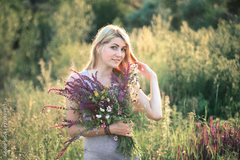 Portrait of a young beautiful woman in the nature with a bouquet of flowers. Portrait of a young beautiful woman in the nature with a bouquet of flowers.