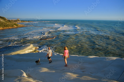Couple walking with their dog on the extraordinary promontory of the scala dei Turchi of Realmonte in the province of Agrigento in Sicily