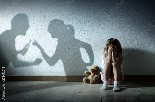 Little Girl Crying With Shadow Of Parents Arguing - Home Violence And Divorce photo