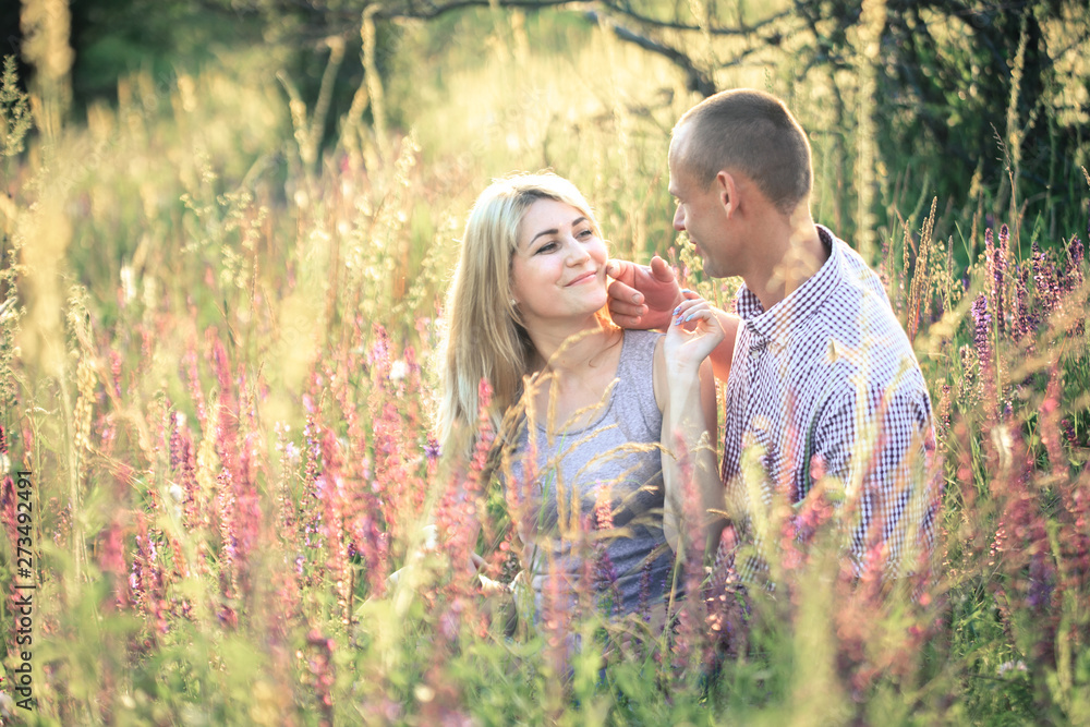 Young couple in the summer on the nature. The concept of relationships, love and relaxation. Young couple in the summer on the nature. The concept of relationships, love and relaxation.