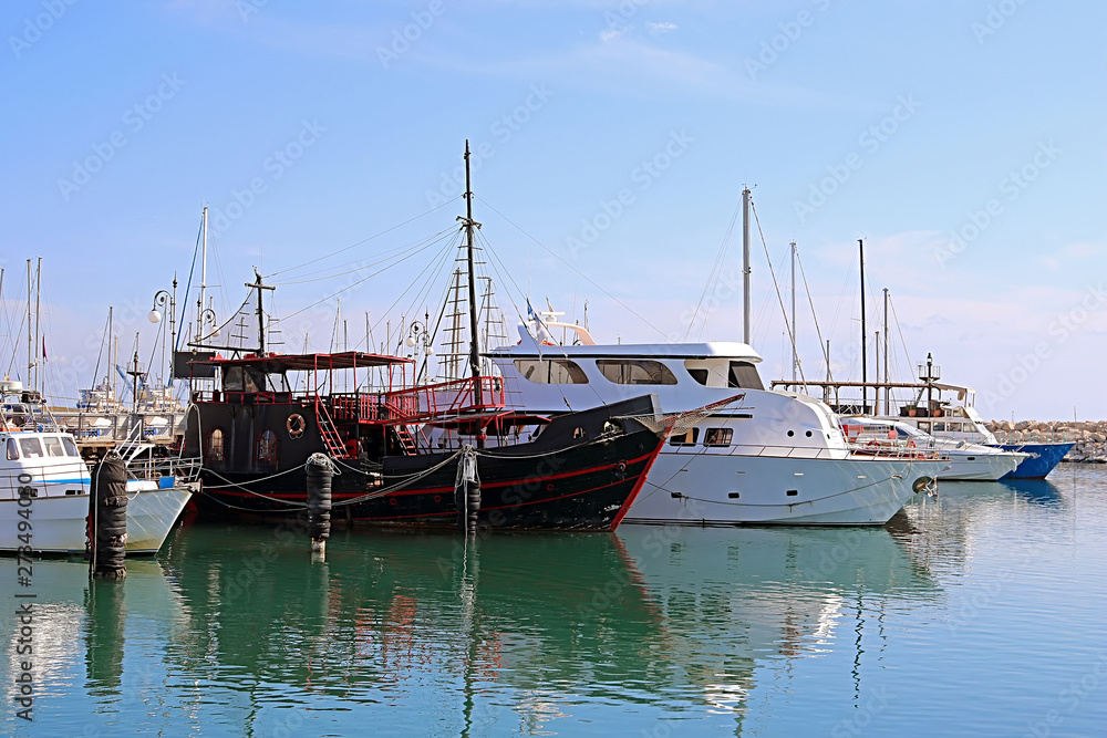 Yachts in Larnaca port, Cyprus. One black boat is different from the others - it looks like a pirate ship