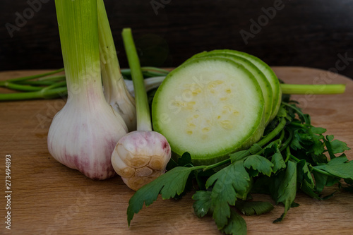 Sliced ​​zucchini, garlic and parsley close-up on a cutting board