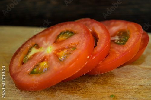 Sliced ​​tomatoes on the rings close-up on a cutting board