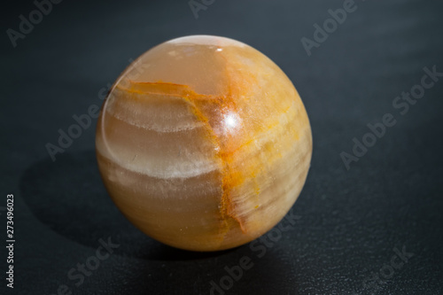 Foto Opal moonstone yellow in the shape of a sphere of a ball on a black background c