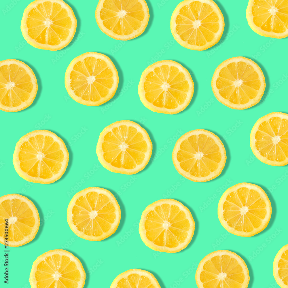 Summer fruit pattern of lemon slices on a teal background Summer fruit pattern of lemon slices on a teal background