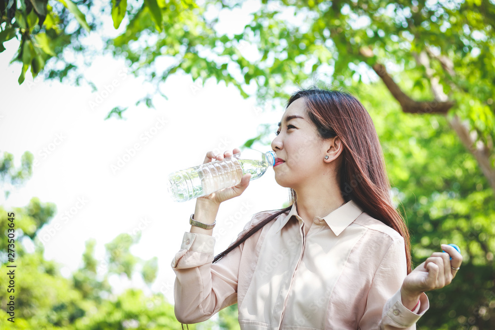 Working women are drinking clean water. It makes her body refreshed.
