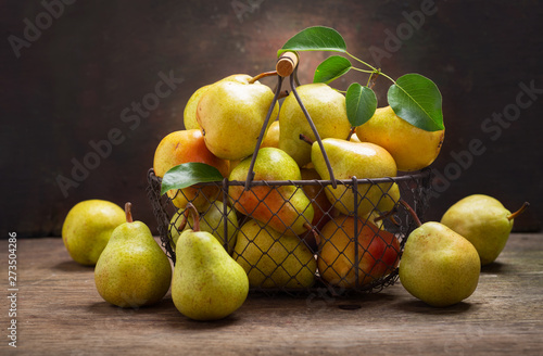 fresh ripe pears with leaves in a basket
