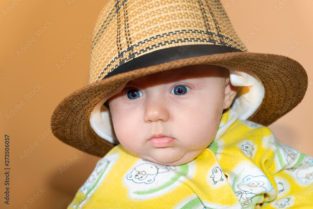 Portrait of a child, a little girl in a straw hat, in the studio on a beige background. Portrait of a child, a little girl in a straw hat, in the studio on a beige background.
