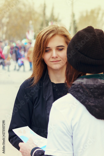 Фотография The agitator on the street offers a passer-by to a girl to take a leaflet