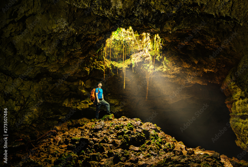 Cave in the Azores with backpacker - obrazy, fototapety, plakaty 