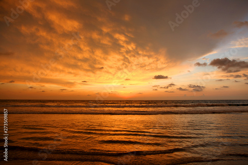 Fototapeta Naklejka Na Ścianę i Meble -  Bright pink and orange sunset reflecting on the waves
