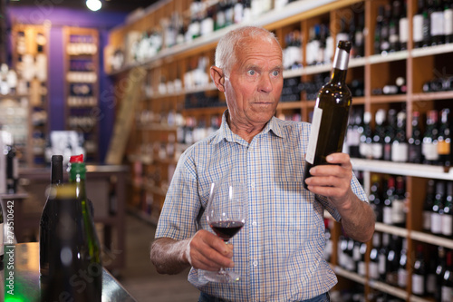 Man tasting wine in wine store photo