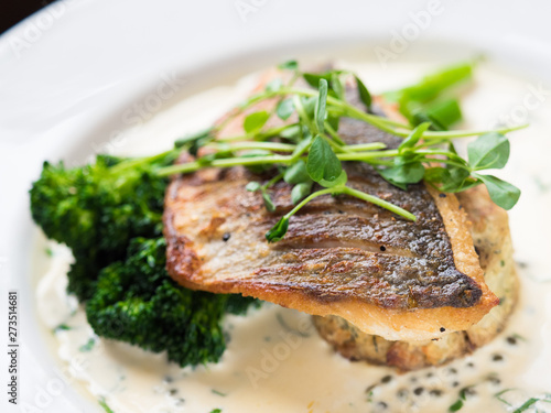 Pan fried fish with vegetables. Restaurant dish.