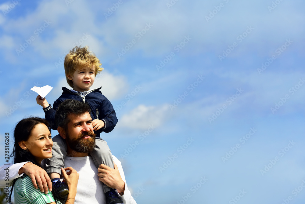Imagination. Father and son building together a paper airplane. Portrait of happy father giving son piggyback ride on his shoulders, hug wife and looking up. Funny time. Childhood. Imagination. Father and son building together a paper airplane. Portrait of happy father giving son piggyback ride on his shoulders, hug wife and looking up. Funny time. Childhood.