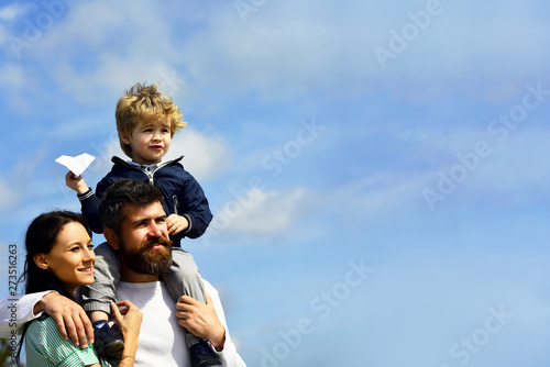 Imagination. Father and son building together a paper airplane. Portrait of happy father giving son piggyback ride on his shoulders, hug wife and looking up. Funny time. Childhood.