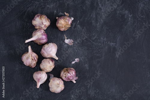 few garlic heads on dark background. top view. copy space