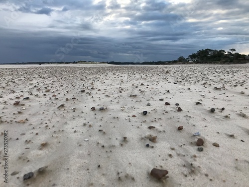 Storm clouds in Pinamar beach and sand with stones photo