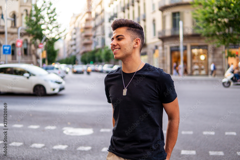 Young fashionable handsome man on the street of modern city. He looks happy and smiling Young fashionable handsome man on the street of modern city. He looks happy and smiling