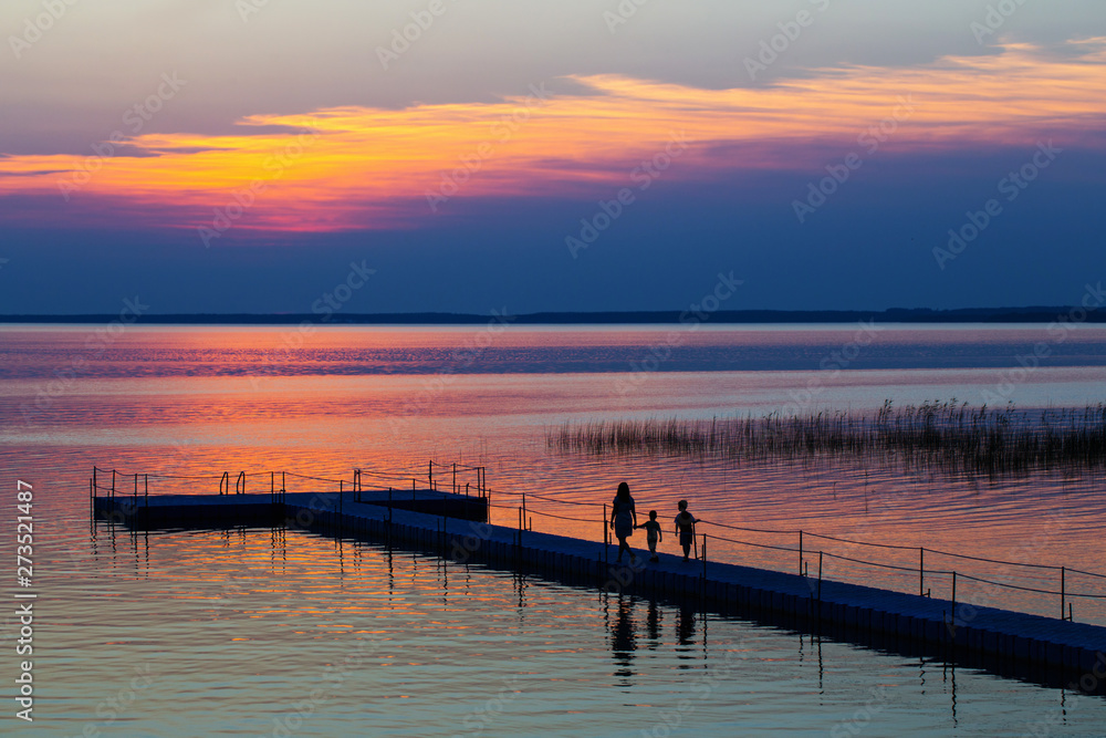 Fototapeta premium family on pontoon pier at sunset