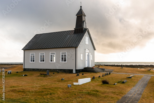 Fototapet Lonely chapel onthe coast of Iceland at sunset in autumn