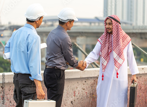 Concept of Negotiating business and handshake Gesturing People Connection Deal. Arabic businessman giving an shaking hands to his business partner or customer on construction site background,fair play © Joke Phatrapong