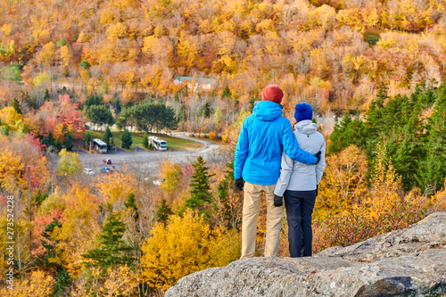 Couple hiking at Artist's Bluff in autumn. Fall colours in Franconia Notch State Park. White Mountain National Forest, New Hampshire, USA