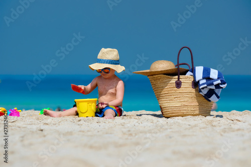Obraz na płótnie Two year old toddler boy playing with beach toys on beach w salonie