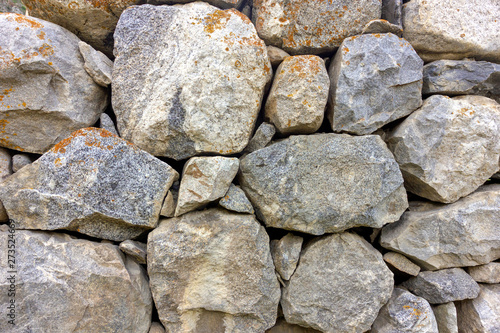 The old wall of natural stone in the mountains, covered with moss.