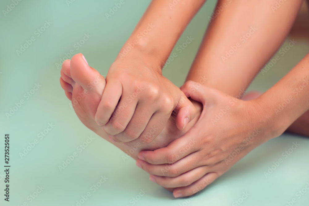 Woman feels strong foot pain isolated. People, healthcare and medicine concept Woman feels strong foot pain isolated. People, healthcare and medicine concept