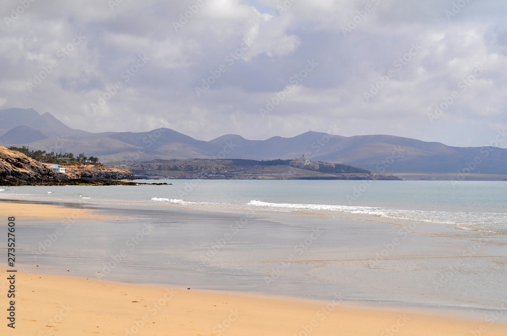 Sandy ocean beach with mountains on background. Costa Calma, Fuerteventura, Canary Islands