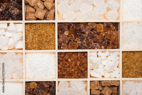 Various kinds of sugar in a wooden box. White refined, brown cane sugar collection