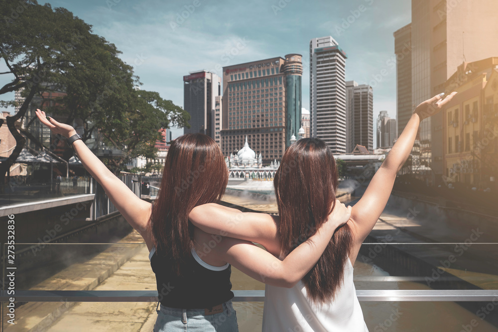 Naklejka premium Rear of two young women enjoy holiday in Kuala Lumpur, Malaysia