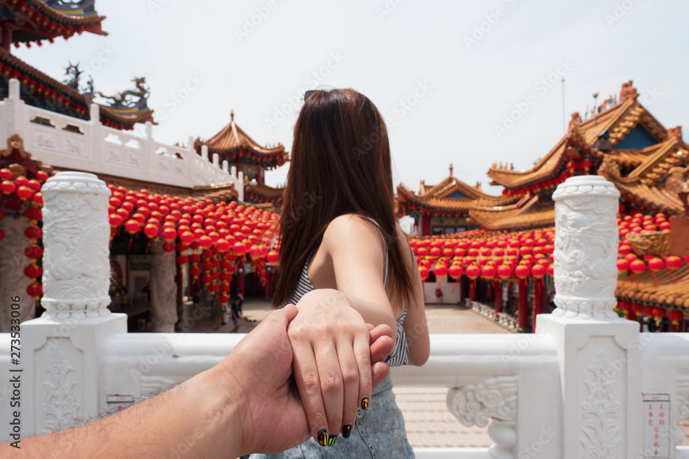 Naklejka premium Young woman holding man hand travel in Thean Hou Temple in Kuala Lumpur, Malaysia