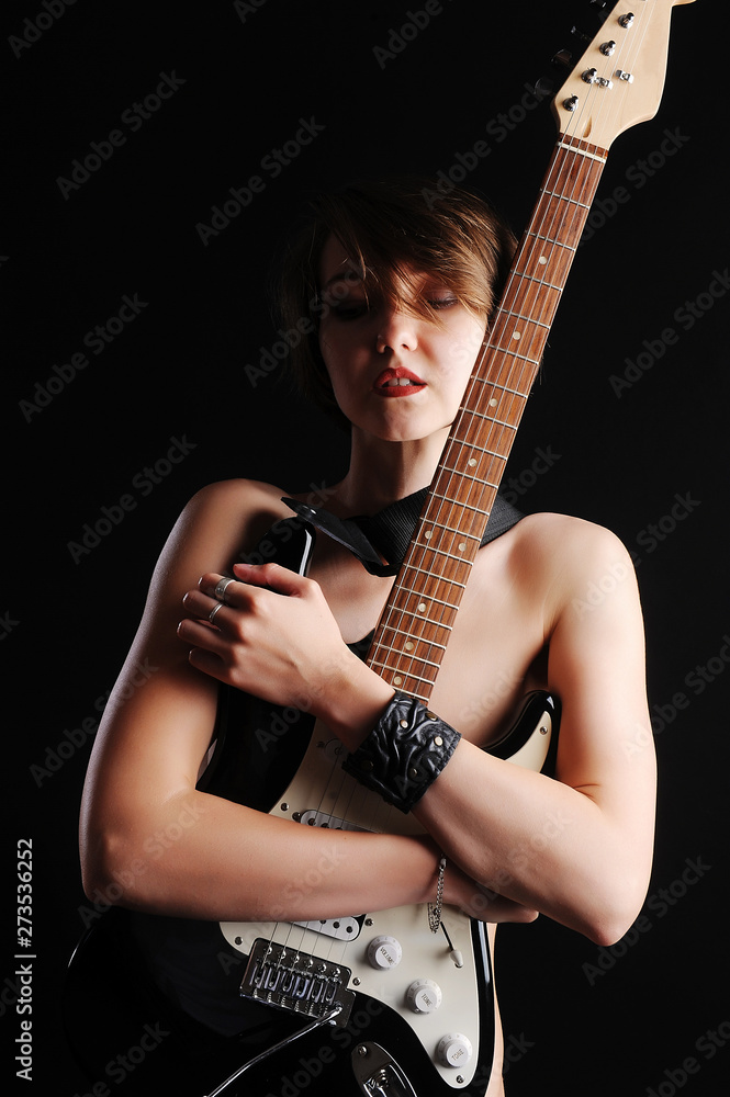 Beautiful sexy girl with electric guitar on a black background Stock Photo  | Adobe Stock
