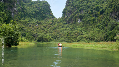 Boat with tourists, karst mountains and river, Trang An, Ninh Binh, Tam Coc, Vietnam. 