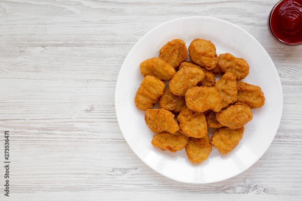 Chicken nuggets and ketchup on a white wooden background. Overhead, from above, flat lay. Copy space. Chicken nuggets and ketchup on a white wooden background. Overhead, from above, flat lay. Copy space.
