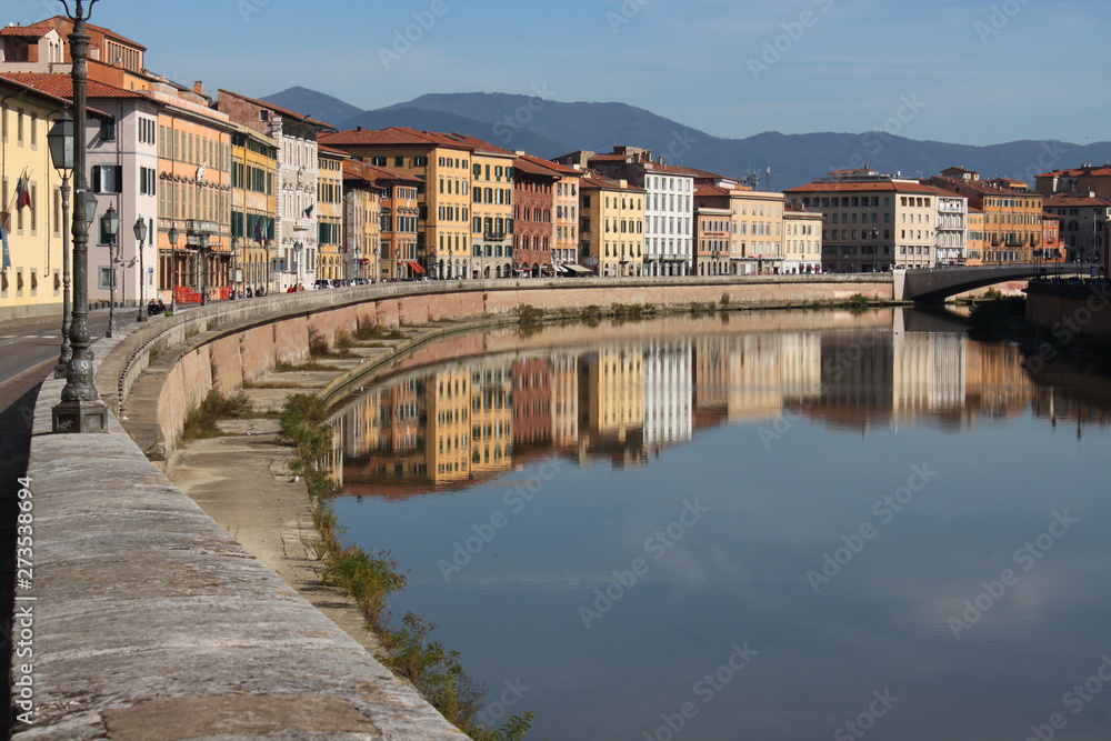 Colorful house facades at Arno river in Pisa, Italy, on a sunny morning