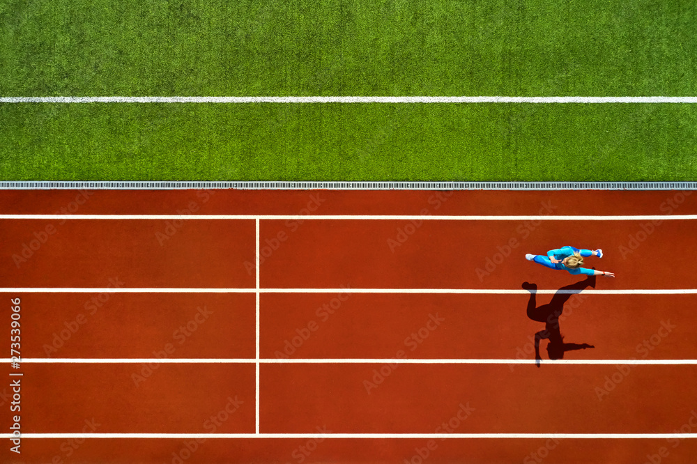 Obraz premium Athletic blonde woman running at open stadium