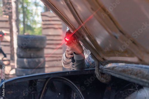 Laser tag player shooting a gun from an ambush at a training ground. photo