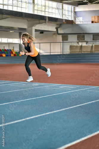 Athletic blonde woman training at indoor stadium © Andriy Bezuglov