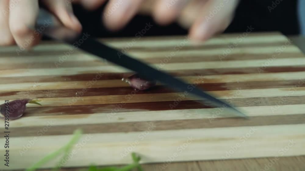 Peeling off skin from garlic clove on wooden table top background. Woman hands prepare food. Garlic cloves peeled by hands, close up. Peeling off skin from garlic clove on wooden table top background. Woman hands prepare food. Garlic cloves peeled by hands, close up.