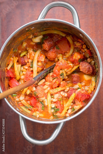 Fried sausage with beans, tomatoes, garlic in tomato sauce  photo