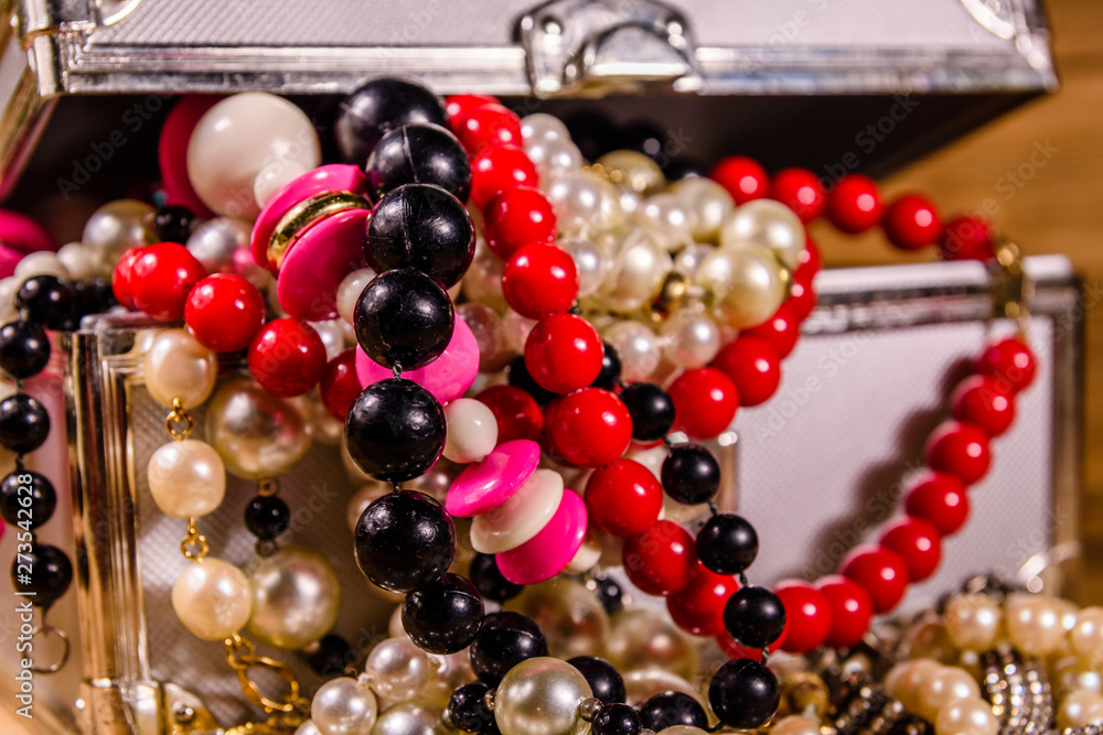 Aluminium case full of different jewelry on wooden table Aluminium case full of different jewelry on wooden table