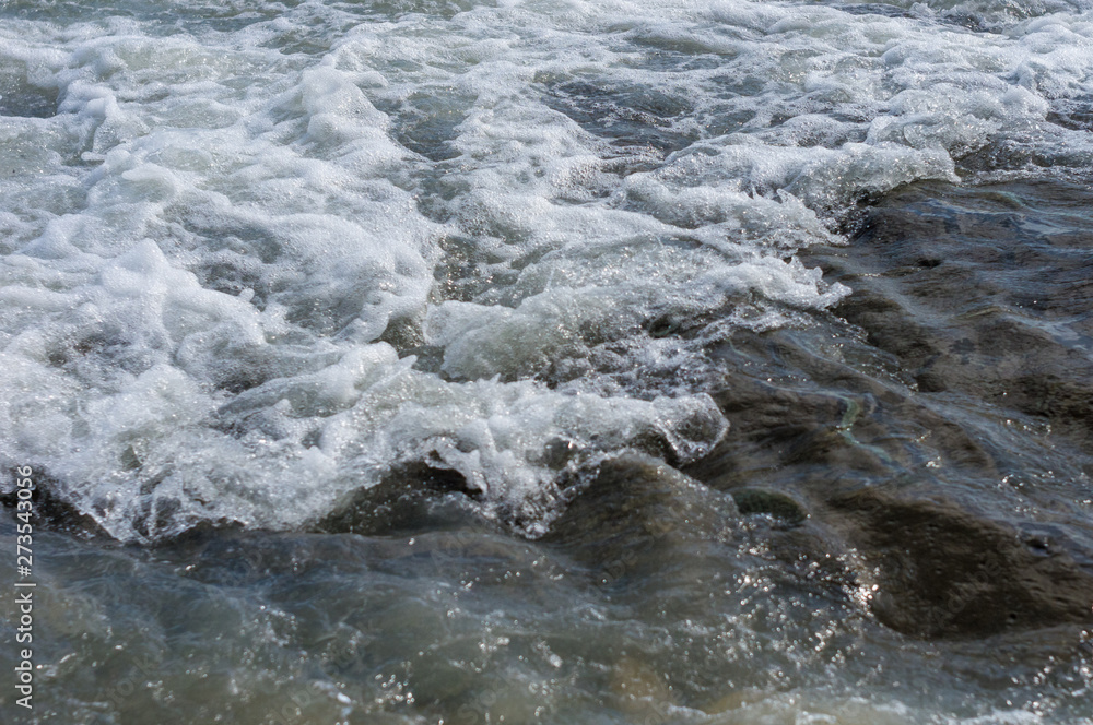 pebble stones on the sea beach, the rolling waves of the sea with foam pebble stones on the sea beach, the rolling waves of the sea with foam