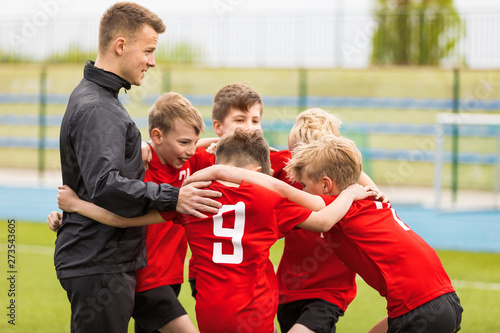Coaching Youth Sports. Kids Soccer Football Team Huddle with Coach. Children Play Sports Game. Sporty Team United Ready to Play Game. Youth Sports For Children. Boys in Sports Jersey Red Shirts