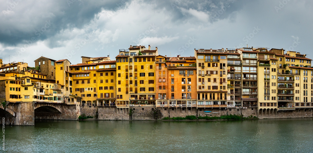 Colorful old buildings line the Arno River in Florence, Italy, at the east end of the Ponte Vecchio (