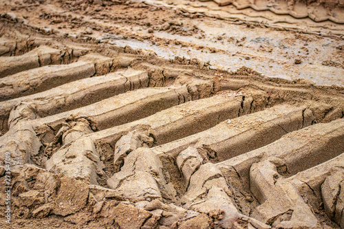 excavator tire tracks in the sand; structured background
